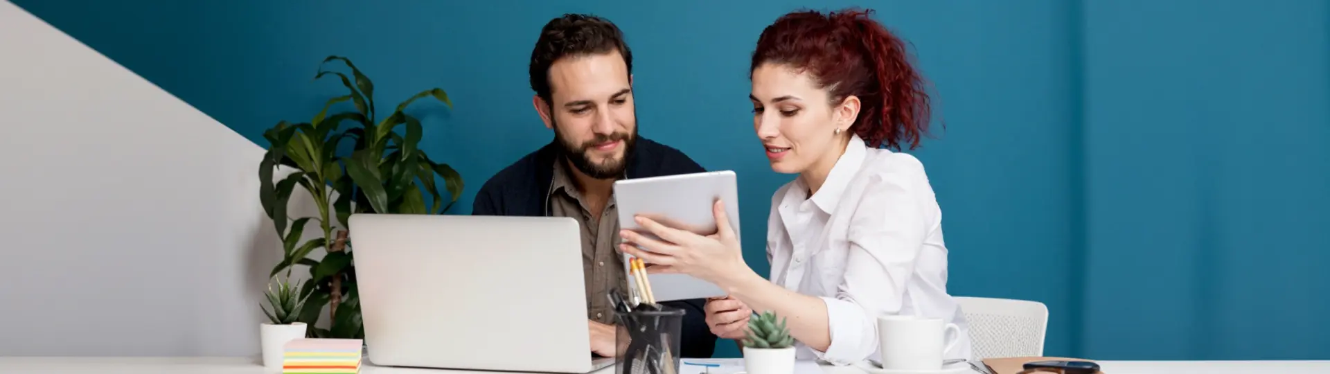 Paar plant am Schreibtisch mit Laptop und Tablet die nächste Anschaffung
